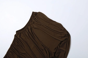 Gros plan détaillé du tissu froncé marron foncé montrant des plis et une maille élastique