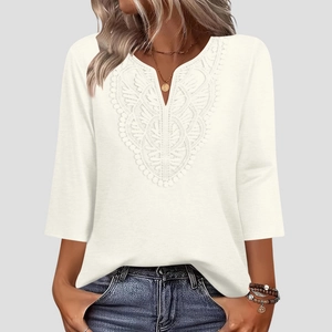 Detail of the intricate lace embroidery on a V-neck off-white three-quarter sleeve top