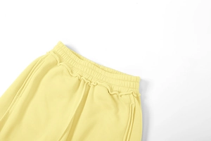Detail des elastischen Hochbunds mit Rüschenbesatz an cremegelben Strickhosen für Damen