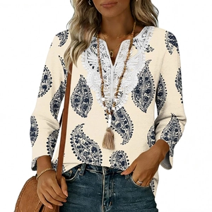 Dettaglio dell'elegante pizzo bianco sullo scollo a V con stampa paisley blu navy