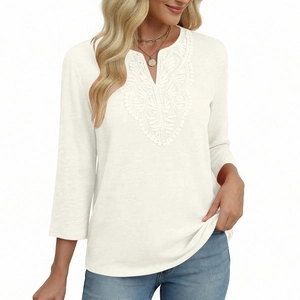 Close-up of V-neckline featuring delicate lace embroidery on this white 3/4 sleeve top