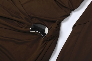 Détail du tissu marron foncé avec une boucle argentée polie en forme de croissant