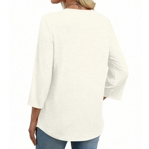 Detail view of the back of a cream V-neck top with lace trim and curved hemline