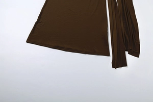 Gros plan d'une robe marron foncé montrant le détail élégant de l'ourlet à ruban