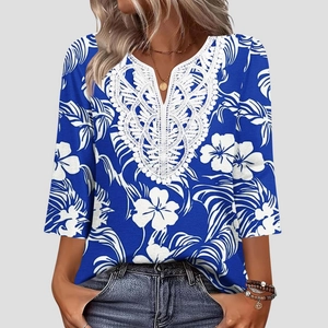 Dettaglio dello scollo a V in pizzo e stampa floreale bianca su questo top blu donna