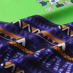 Detailed close-up of vibrant tribal print and geometric patterns on green fabric
