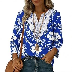 Dettaglio dell'elegante pizzo bianco sullo scollo a V di una blusa blu a fiori boho