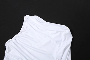 Détail d'une robe blanche à épaule dénudée avec tissu plissé élastique et texture satinée