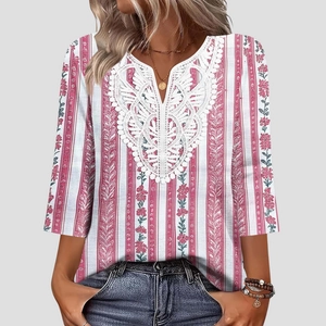 Dettaglio dello scollo a V con inserto in pizzo bianco su camicetta a fiori