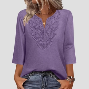 Detail of elegant V-neckline with ornate lace appliqué on this lilac solid color blouse