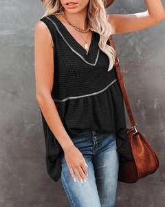 Detail shot of black waffle knit sleeveless V-neck top with silver waist trim decoration