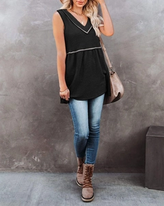 Detail of a black waffle texture V-neck sleeveless top with contrast trim on a model