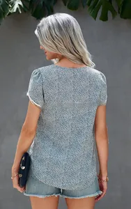 Detail of delicate white lace trim on a blue floral short-sleeve shirt for women