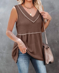 Detail of dark brown waffle knit texture on V-neck sleeveless top with contrast trim