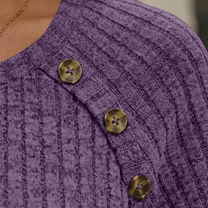Detail of purple ribbed knit top showing diagonal placket with brown tortoise buttons