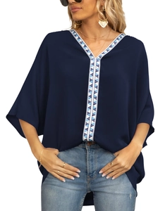 Detail of navy blue V-neck chiffon top featuring geometric embroidered trim and batwing sleeves
