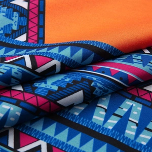 Close-up of vibrant tribal print fabric with orange and blue geometric patterns
