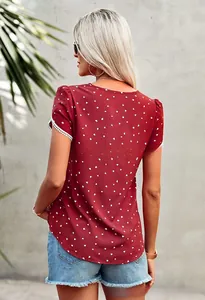 Detail of red short sleeve top featuring white heart print and delicate lace trim on cuffs