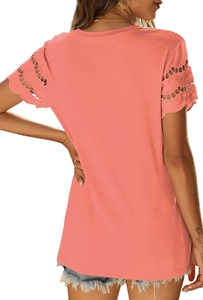 Detail of coral orange short-sleeved T-shirt showing delicate lace embroidery on the sleeves