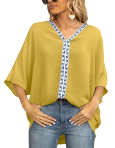 Detail of V-neck yellow blouse with ethnic blue and white geometric embroidered trim