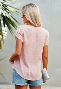 Detail of pink short sleeve top with white dots and lace trim on the sleeve cuffs