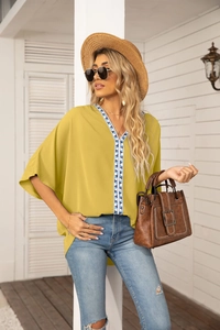 Close-up of V-neckline with blue geometric embroidery on mustard chiffon blouse
