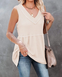 Close-up of beige waffle knit sleeveless top with V-neckline and rib-knit details