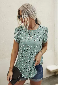 Detail of mint green polka dot blouse featuring delicate white lace trim and puff sleeves