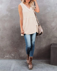 Detail of waffle knit sleeveless top in beige with V-neckline and textured finish
