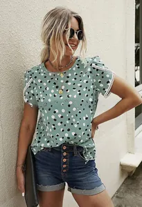 Close-up of white crochet lace trim on green polka dot short sleeve t-shirt