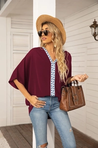 Detail of V-neckline with blue geometric embroidery on burgundy batwing chiffon blouse