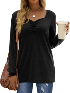 Detail of ruched V-neckline on long-sleeve black top paired with denim jeans