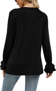 Detail view of female model wearing black long sleeve top with elegant ruffle cuffs
