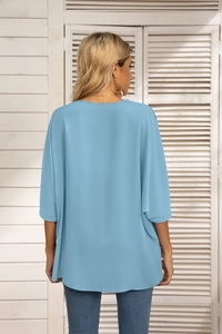 Rear view of a light blue loose chiffon blouse with batwing sleeves and round neckline