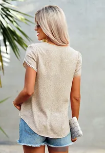 Close-up of elegant lace patchwork detailing on a beige floral print t-shirt sleeve