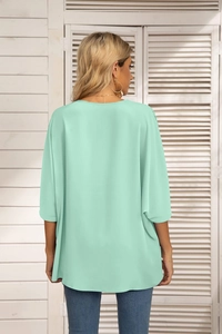Back view of mint green loose chiffon blouse with batwing sleeves and round neckline