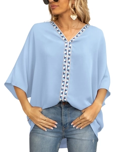 Detail of V-neckline with geometric tribal embroidery on light blue chiffon blouse