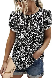 Close-up detail of white lace pom-poms on sleeve cuffs of a floral short sleeve blouse