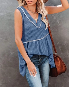 Detail of blue waffle knit texture and V-neckline with white trim on a summer tank top