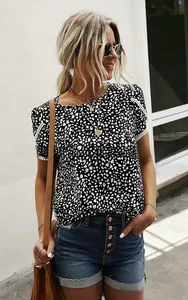 Detail of elegant black and white polka dot top with white lace edge on short sleeves