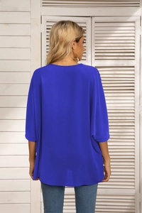 Back view of a loose royal blue chiffon top with batwing sleeves and round neckline