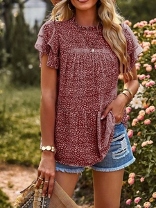 Detailed view of dark red polka dot chiffon blouse with ruffled sleeves and tiered hemline