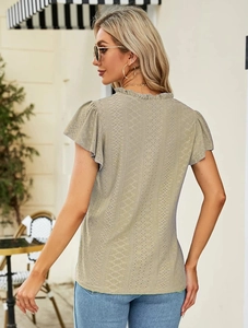 Detail of hollow-out lace texture and scalloped edges on a V-neck summer top