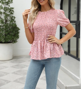 Detailed view of smocked pink floral top with puff sleeves and peplum hem for summer