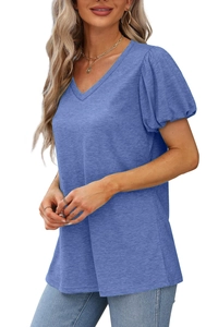 Détail du t-shirt bleu à col en V montrant le tricot texturé et les manches bouffantes