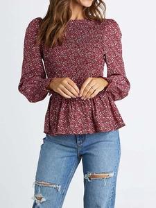 Detail of smocked elastic waist and white floral pattern on wine red long sleeve shirt
