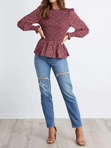 Detail of smocked waist floral blouse with elastic cuffs and peplum hem design