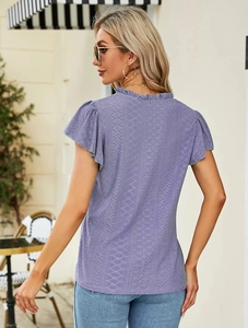 Close-up of light purple lace top featuring delicate eyelet embroidery and ruffle trim