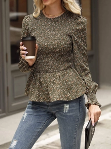 Detail of floral smocked waist top with long sleeves and elegant peplum hem in dark green