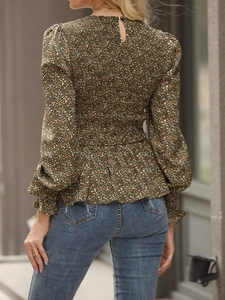 Detail of smocked waist and ruffles on a green floral long sleeve blouse for women